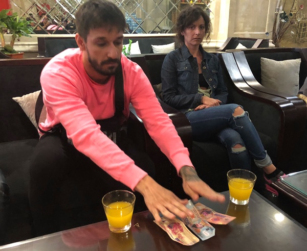 Hai du khách Tây Ban Nha bàn giao số tiền “âm phủ” do tài xế taxi trả lại (ảnh do cơ quan Công an cung cấp)